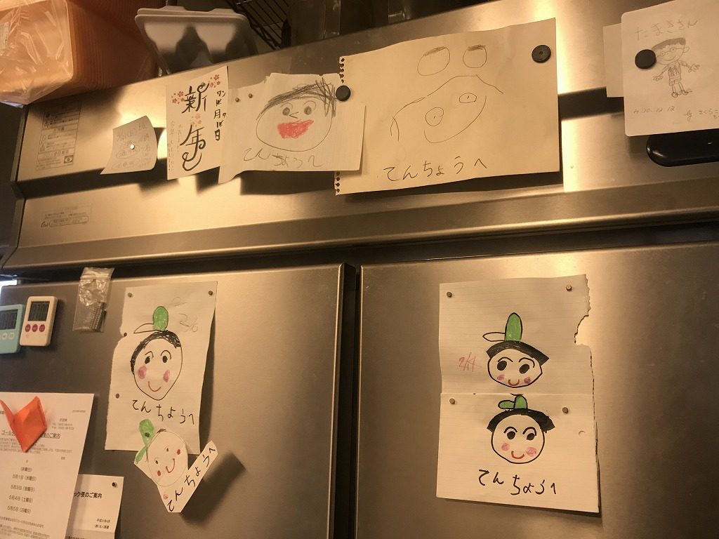 子ども達の描いた似顔絵が貼られた冷蔵庫